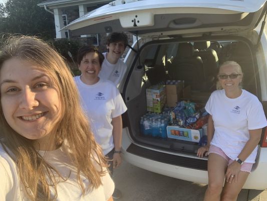 VIEWS Digital Marketing team members Jenny and Mary with Jenny's children helpers loading up the van with supplies