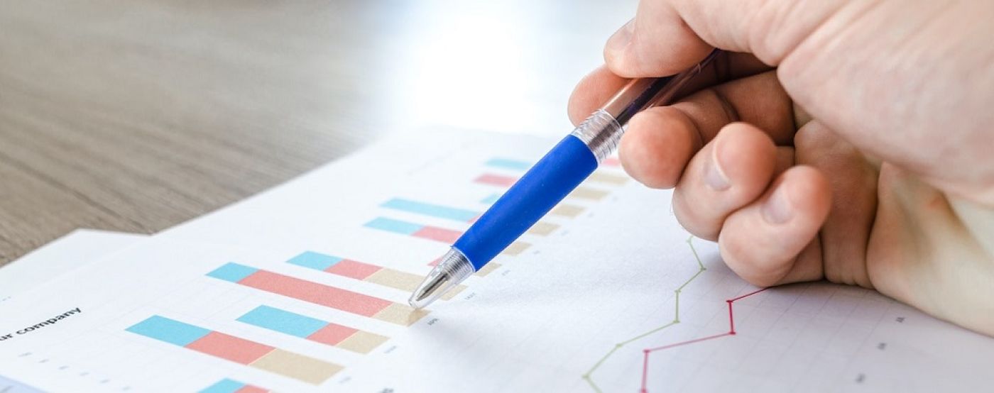 Business person pointing at chart on table with pen