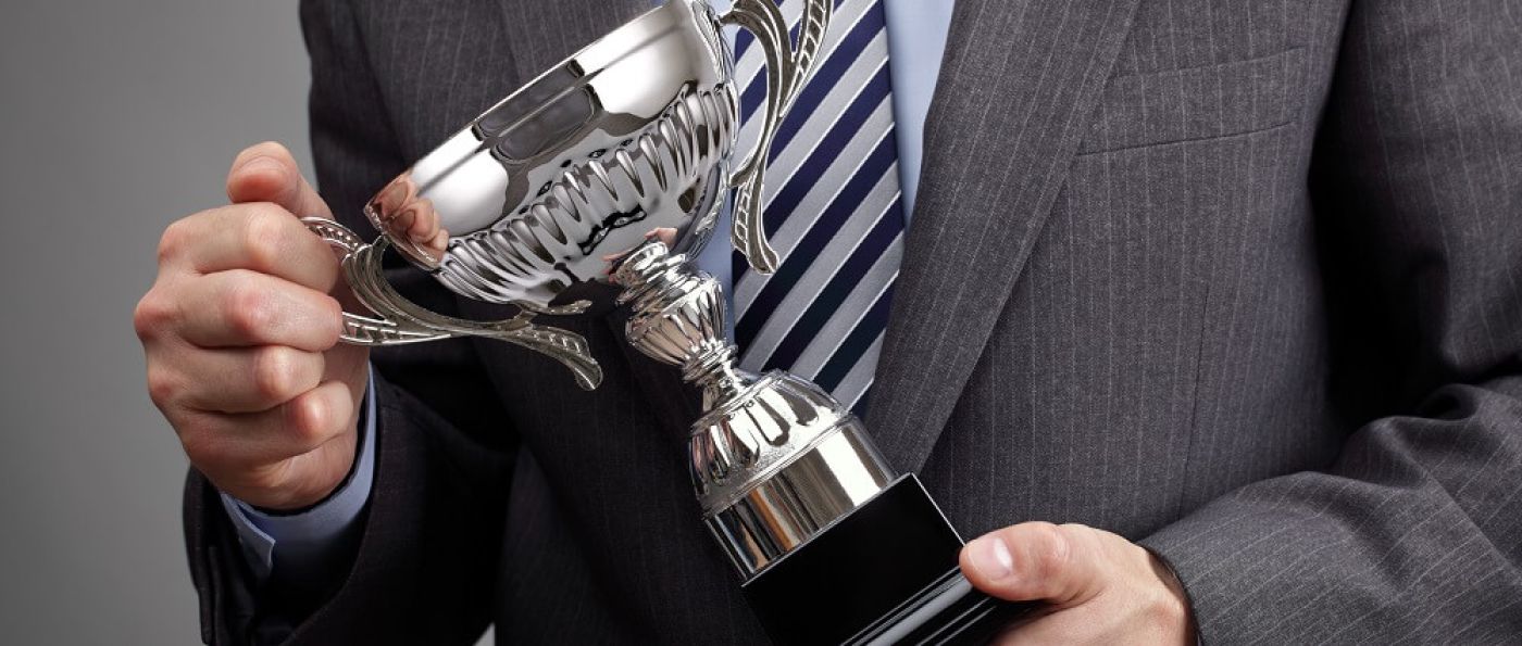 Business man holding trophy | 2020 WebAwards | VIEWS Digital Marketing