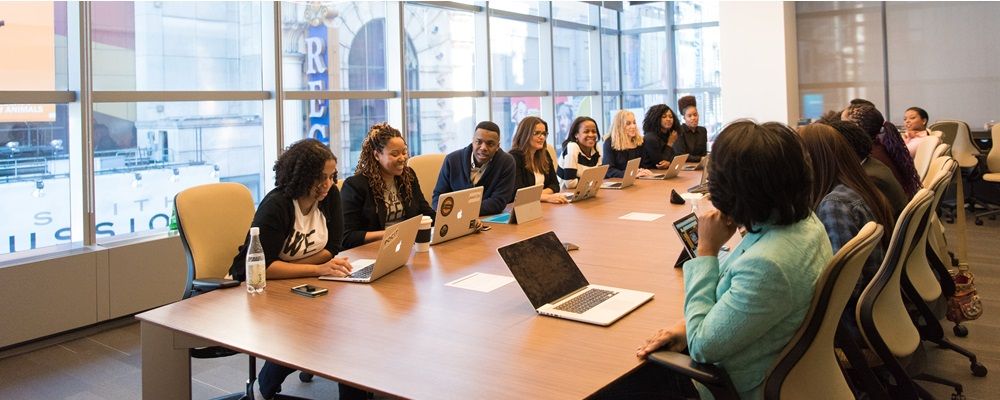 Group of people sitting beside rectangular wooden table with laptops | top woman-owned company in Philadelphia | VIEWS Digital Marketing